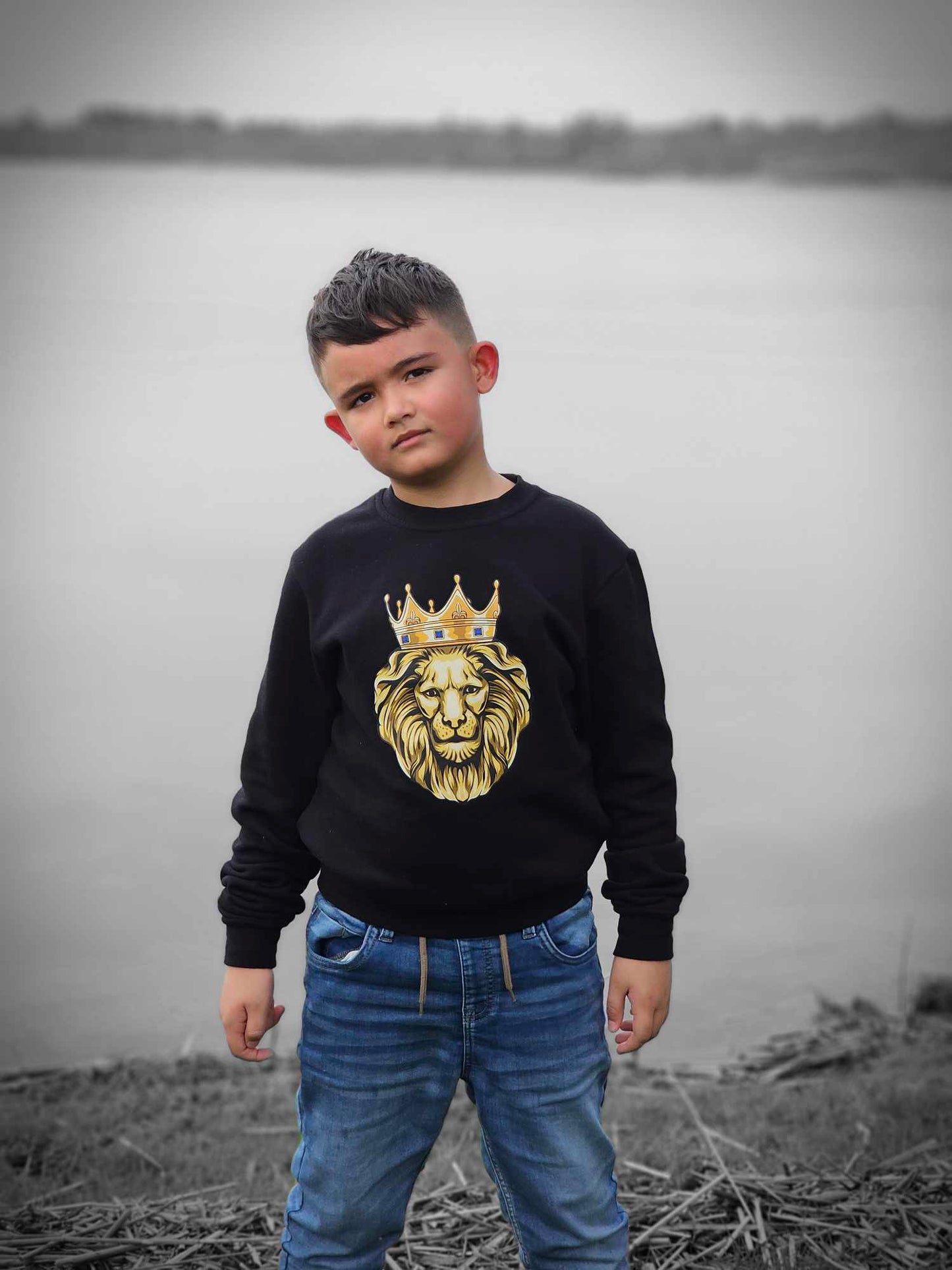 young boy at lake wearing our GOLD LION sweatshirt