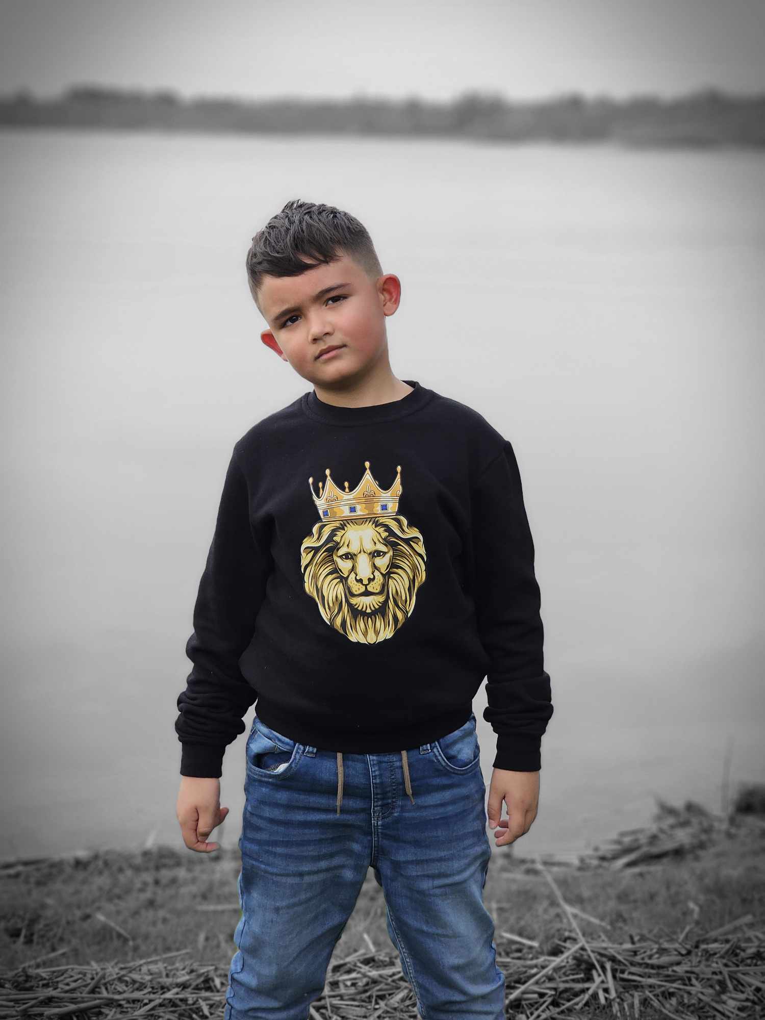 young boy at lake wearing our GOLD LION sweatshirt