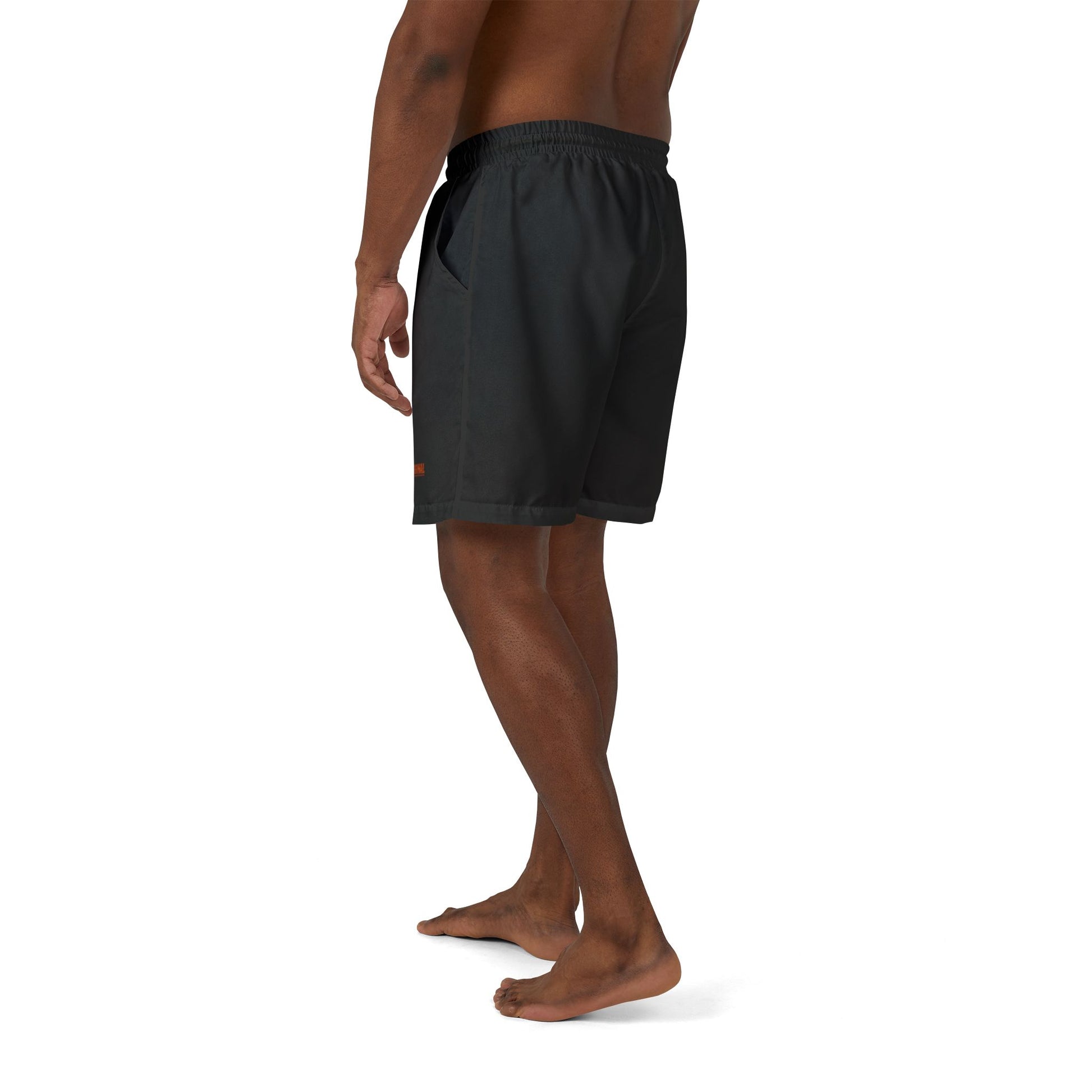 Man wearing black Christian swim shorts by THE ORIGINAL with red logo, side view – faithwear summer collection