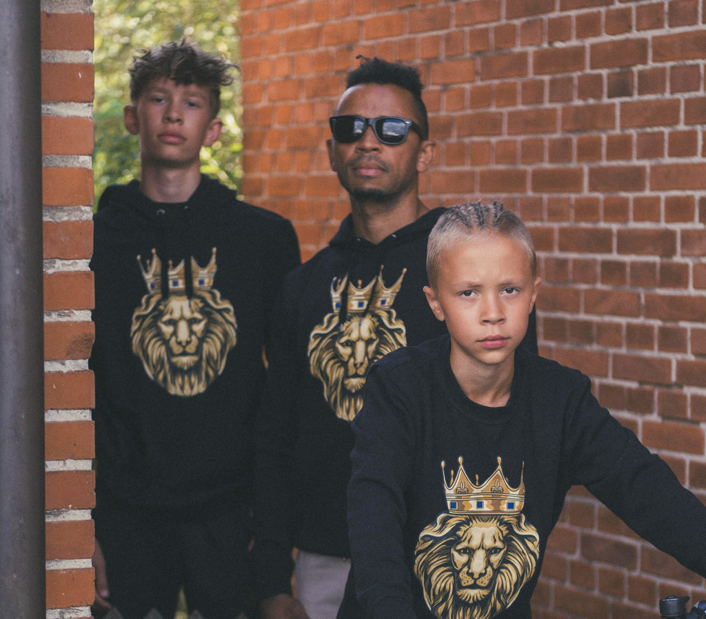 three persons in all black hoodies and sweatshirt with our imprint GOLD LION