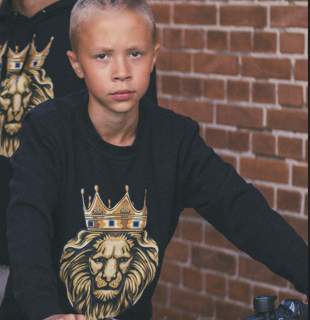 boy in black sweatshirt with GOLD LION imprint from The Original